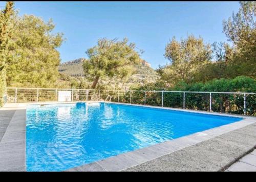 une grande piscine bleue entourée d'une clôture. dans l'établissement Les Hesperides par Dodo à Cassis, à Cassis