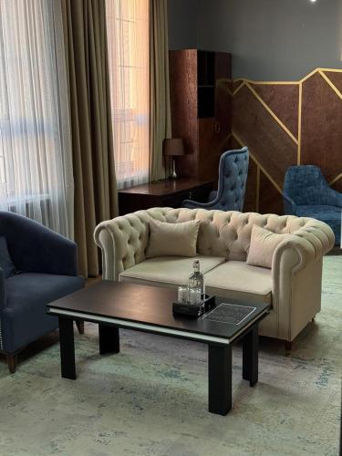 a living room with a couch and a coffee table at WIND HOTEL in Shymkent