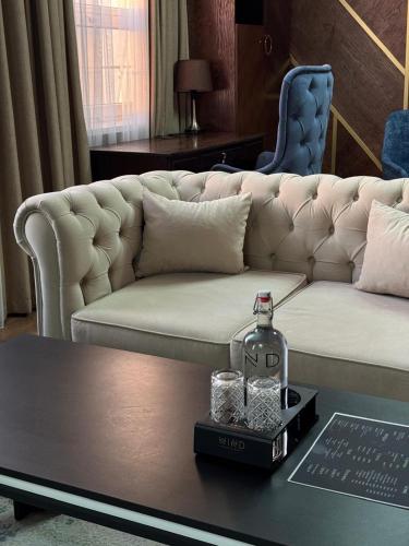 a living room with a white couch and a table at WIND HOTEL in Shymkent