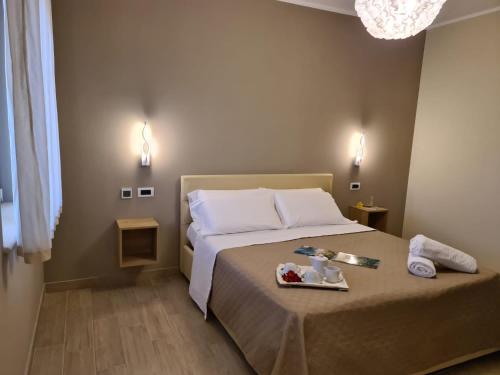 a bedroom with a bed with a tray of food on it at Hotel La Campagnola in Capo Vaticano