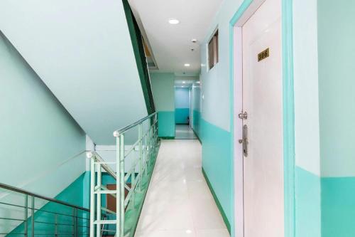 un couloir avec des murs bleus et un escalier dans l'établissement Lucky Hotel Binondo, à Manille