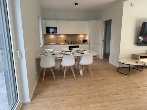 a kitchen and dining room with a table and chairs at Appartement NEUF, 6 personnes, 2 chambres in Ohligsmühle