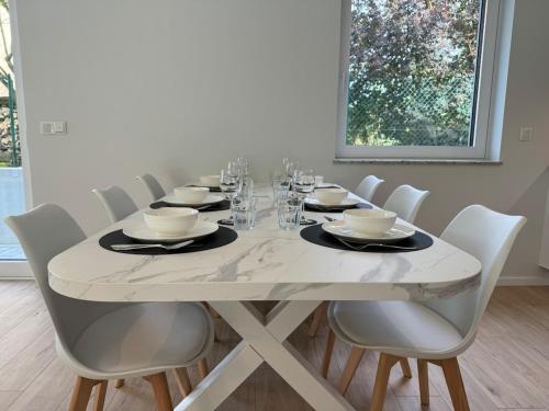 a white dining room table with white chairs and a white tablestration at Appartement NEUF, 6 personnes, 2 chambres in Ohligsmühle