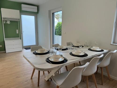 a dining room with a white table and chairs at Appartement NEUF, 6 personnes, 2 chambres in Ohligsmühle