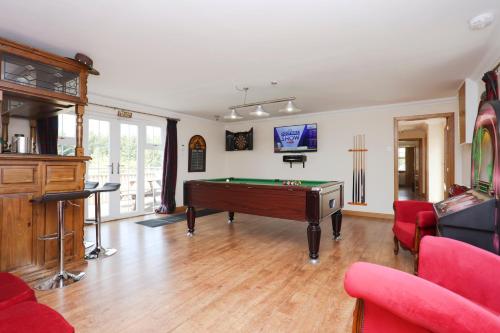 a living room with a pool table in it at JOIVY Greenknowes Farmhouse with Hot Tub and Bar in Kelty
