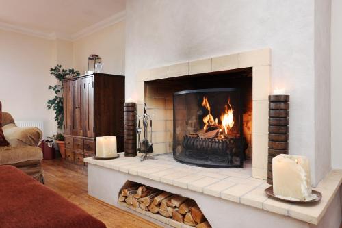 a fireplace in a living room with a fire in it at JOIVY Greenknowes Farmhouse with Hot Tub and Bar in Kelty