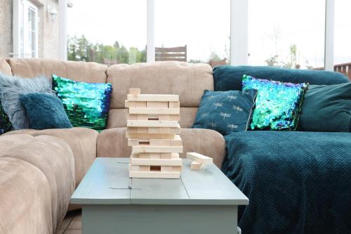 a coffee table in a living room with a couch at JOIVY Greenknowes Farmhouse with Hot Tub and Bar in Kelty