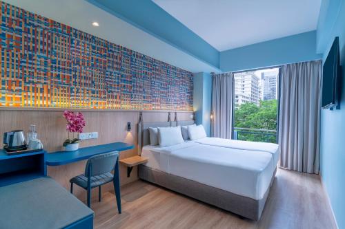 een hotelkamer met een bed, een bureau en een raam bij ibis Styles Kuala Lumpur Bukit Bintang in Kuala Lumpur