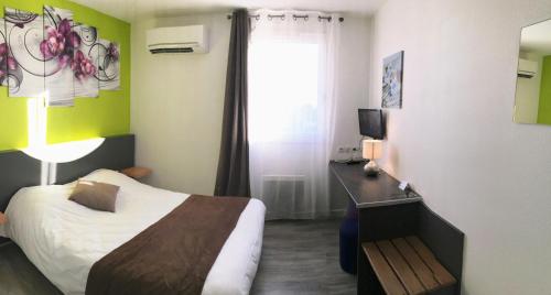 a bedroom with a bed and a desk and a window at L'Hôtel du Marais Romilly Centre in Romilly-sur-Seine