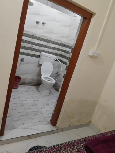 a bathroom with a toilet in a room at Geeta Teerth Guest House AC and Non AC Rooms in Ayodhya