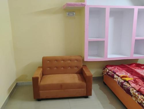 a brown chair in a room with a bed at Geeta Teerth Guest House AC and Non AC Rooms in Ayodhya