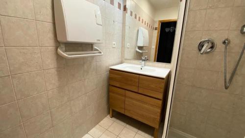 une petite salle de bain avec un lavabo et une douche dans l'établissement Résidence Alpages Bellevue - Superbe studio au calme, avec jardin et vue magnifique MAE-5241, à Montgenèvre