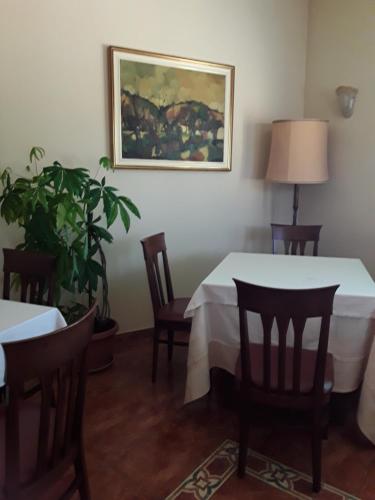 a dining room with a table and chairs and a painting at Albergo Al Portico in Azzano Decimo