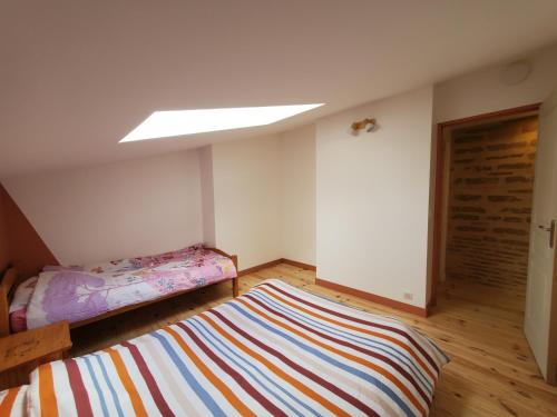 a bedroom with a bed and a striped rug at Au Moulin du Miech in Salvagnac