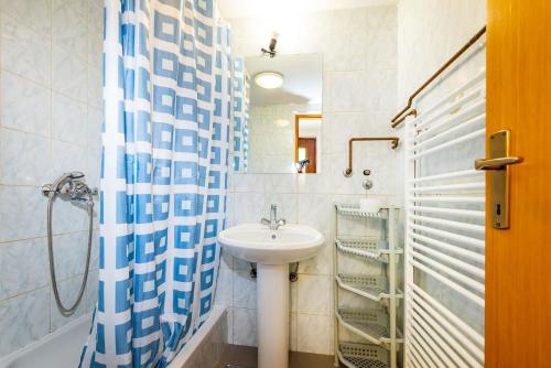 a bathroom with a sink and a shower curtain at Bady Apartments with BBQ in Novalja