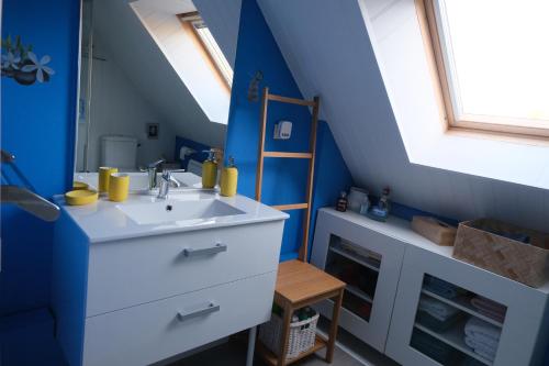 La salle de bains est pourvue d'un lavabo et d'un mur bleu. dans l'établissement La Parquerie, à Orval