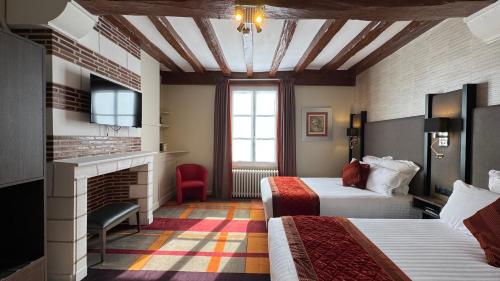 a hotel room with two beds and a fireplace at Hotel Bellevue in Amboise