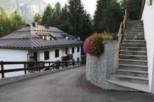 a house with stairs and flowers on the side of it at LaStubediGió in Folgarida