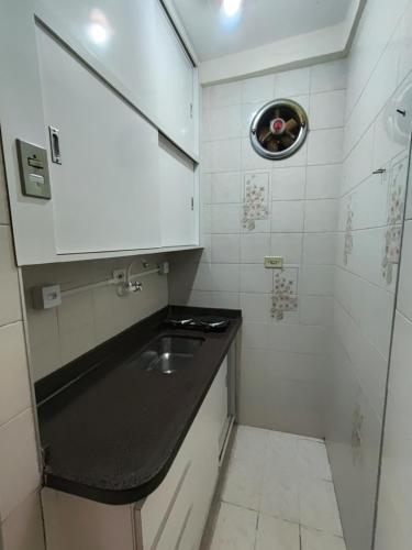 une petite salle de bain avec un lavabo et une douche dans l'établissement Apto central com estacionamento, à Poços de Caldas
