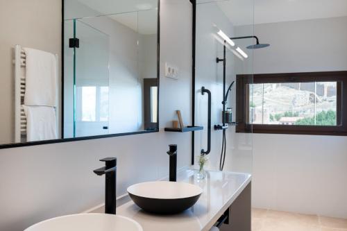 a bathroom with two sinks and a large mirror at Parador de Molina de Aragón in Molina de Aragón
