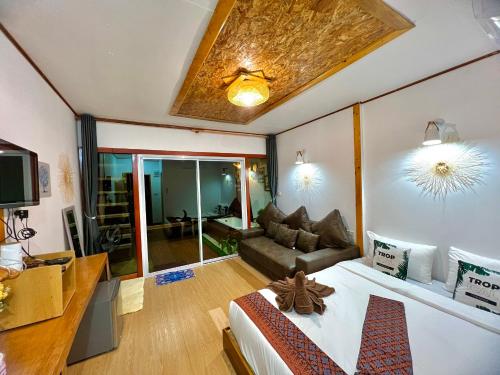 a bedroom with a bed and a couch in a room at Bnเกาะลิบงโฮมสเตย์ in Ko Muk