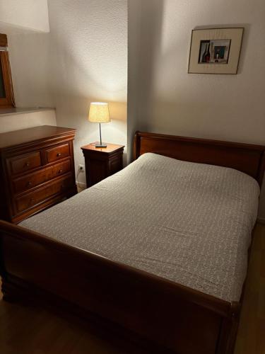 - une chambre avec un lit, une commode et une lampe dans l'établissement Appartement authentique centre historique, à Colmar