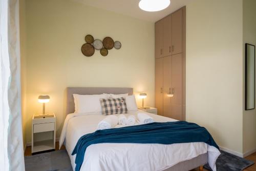 a bedroom with a bed with two towels on it at Mia Homes - Heart of Athens in Athens