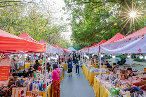 a group of people walking through a market with tables at Ecopark Duplex Homestay by QMP in HÆ°ng YÃªn