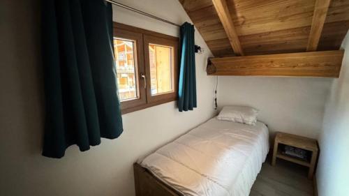 Un dormitorio pequeño con una cama y una ventana. en Chalet Epilobe - Superbe duplex luxe, style refuge. MAE-5161, en Montgenèvre