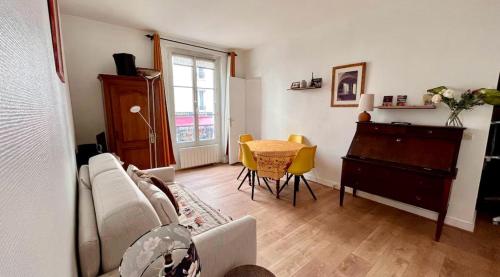 - un salon avec un canapé, une table et un piano dans l'établissement Nid charmant et confortable, à Paris