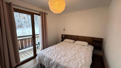 une chambre avec un lit et une grande fenêtre dans l'établissement Chalet Epilobe - Superbe appartement prestige à 50m des pistes MAE-5171, à Montgenèvre