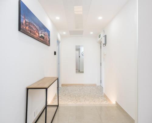 a hallway with white walls and a wooden table at MM Ciampino Rooms in Ciampino