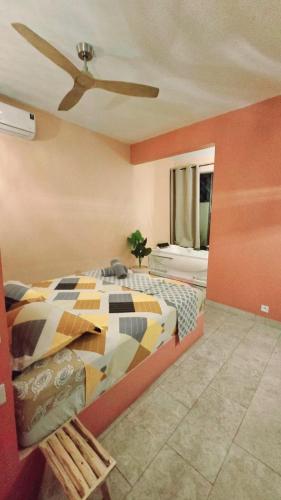 a bedroom with a bed and a ceiling fan at Villa centre Grand Baie in Grand Baie