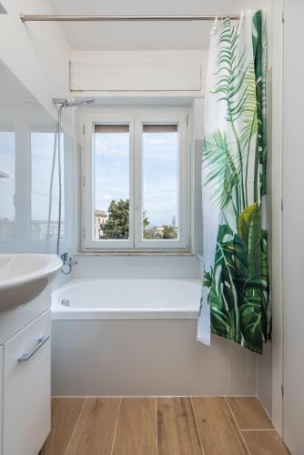 a bathroom with a bath tub and a window at MM Ciampino Rooms in Ciampino