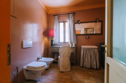 a bathroom with a toilet and a sink and a mirror at Palazzo Romani Adami in Fermo