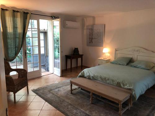 une chambre avec un lit, une table et une fenêtre dans l'établissement La maison à couleur - Mas provençal avec piscine, à Châteaurenard