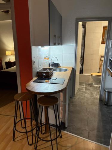 - une cuisine avec deux tabourets de bar et un évier dans l'établissement Appartement authentique centre historique, à Colmar