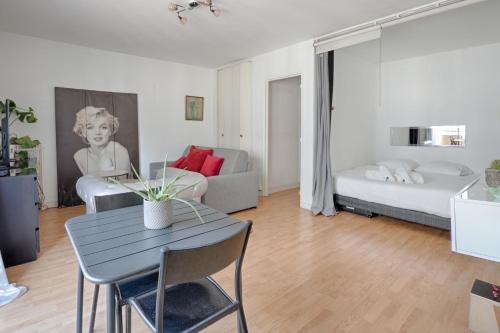 un salon avec une table et un canapé dans l'établissement La Folie Mericourt - A 5 min de Place République, à Paris