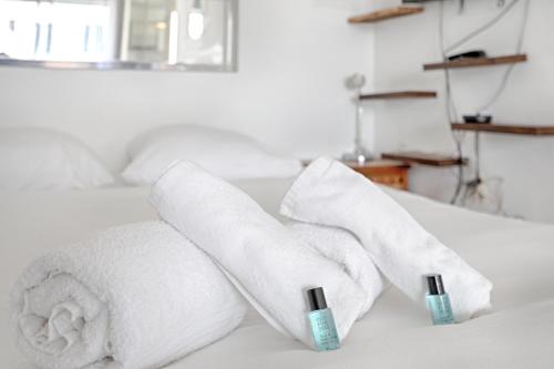 une pile de serviettes posée sur un lit dans l'établissement La Folie Mericourt - A 5 min de Place République, à Paris