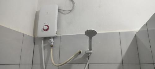 a shower head on a wall in a bathroom at KOMOWANAN HOMESTAY in Kundasang