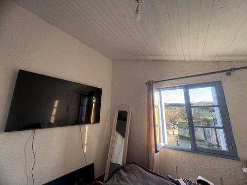 Cette chambre dispose d'une fenêtre et d'une télévision murale. dans l'établissement La maison du soleil, à Villar-Saint-Anselme