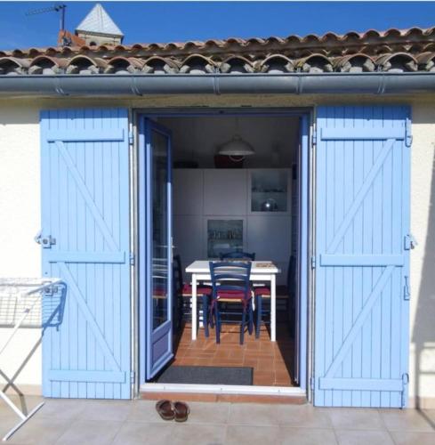 Une porte ouverte s'ouvre sur une terrasse avec une table. dans l'établissement La maison du soleil, à Villar-Saint-Anselme