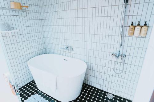 a white toilet in a bathroom with a shower at 洛津做夢-鹿港包棟民宿 Lok-tin Choe-bang House in Lugang