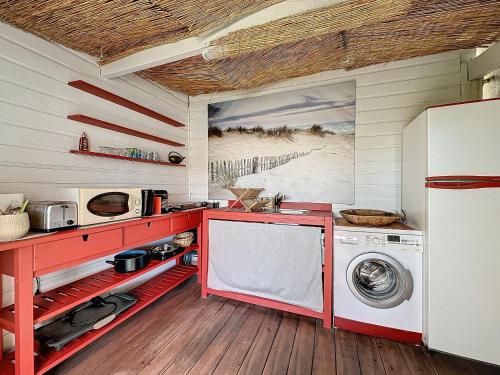 une cuisine avec un comptoir rouge et une machine à laver dans l'établissement Intuition Rooftop vaste terrasse, à Cannes