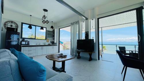 a living room with a couch and a tv and a table at The White House Beach Apartments Koh Phangan in Ban Nua