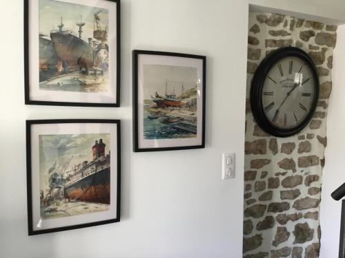 a group of pictures on a wall with a clock at Côté campagne in Pierrefaites