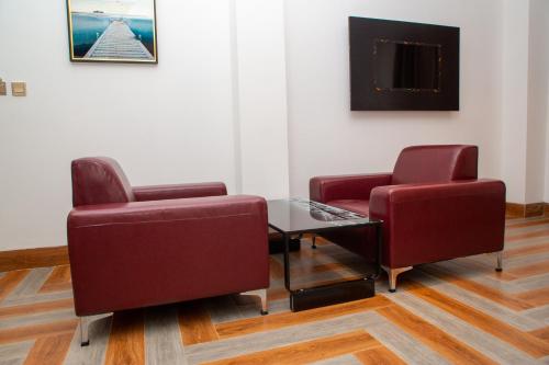 two chairs and a table in a waiting room at Hôtel ZUMAH in Ouagadougou