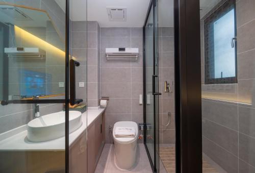 a bathroom with a toilet and a sink and a shower at Yun Guan Shunde Renjia Resort Hotel in Jinghong