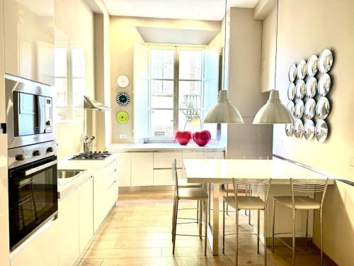 a white kitchen with a table and chairs in it at Casa Cenami in Lucca
