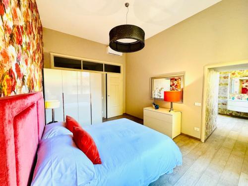 a bedroom with a large bed with red pillows at Casa Cenami in Lucca
